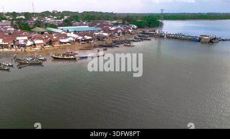 Vista aerea del lungomare di Kaa che mostra una vivace comunità con barche che costellano l'acqua sullo sfondo della lussureggiante vegetazione di Khana, Bori, Nigeria Foto Stock