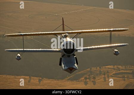 L'immagine mostra un Grumman J-2F-6 Duck Warbird che vola in una fotografia aria-aria con una visuale chiara del cockpit e del pilota. Il J-2F-6 Duck è un biplano anfibio monomotore a due posti sviluppato per la United States Navy e la Guardia Costiera alla fine degli anni '1930 È alimentato da un motore Wright R-1820 Cyclone a pistoni radiali a nove cilindri che aziona un'elica a passo fisso. Questo velivolo restaurato ha la registrazione civile N3960C, numero di serie 33559, ed è operato come parte della Erickson Airshow Collection. Il Duck è stato utilizzato per servizi di utilità, salvataggio, osservazione e trasporto. operazioni Foto Stock