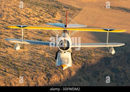 L'immagine mostra un biplano anfibio Grumman J-2F-6 Duck in volo, visto da vicino da una prospettiva aria-aria con il pilota visibile nella cabina di pilotaggio aperta. Questo aeromobile ha la registrazione civile N3960C e il numero di costruzione 33559. Il J-2F-6 Duck fu costruito dalla Grumman come biplano monomotore a due vani con carrello di atterraggio retrattile per le operazioni di terra e di acqua. È alimentato da un motore radiale Wright R-1820 Cyclone a nove cilindri raffreddato ad aria. Questo Warbird restaurato è gestito come parte della Erickson Airshow Collection e rappresenta una configurazione Duck di produzione tardiva. Foto Stock