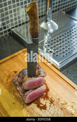 Bella foto del brisket di manzo (punto finale di Brisket). Taglio di carne con coltello in acciaio Damasco forgiato Arkansas Breeze Foto Stock