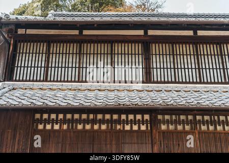 Esterno rustico della casa con facciata giapponese Machiya con finestre in legno, pareti e tetto in piastrelle Foto Stock