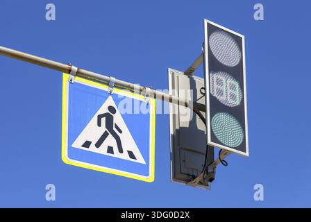 Segno del traffico di attraversamento pedonale e semaforo con cielo blu in background Foto Stock