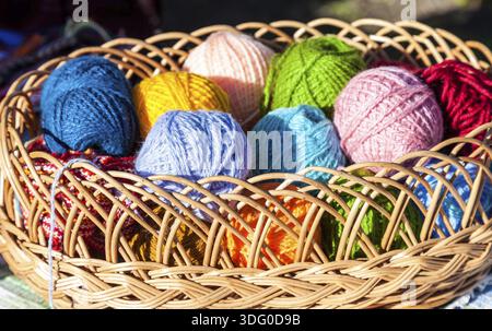 Bright multi-palle colorate di filato nel cesto di vimini Foto Stock