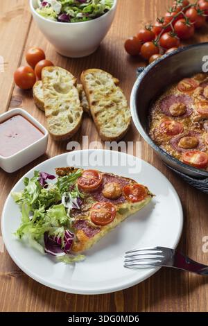 Frittata su piatto bianco con tavolo da colazione Foto Stock