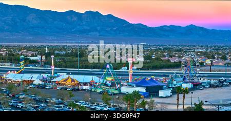 Giostre aeree di Carnevale della zona fieristica di Las Vegas e panorama delle montagne all'ora d'oro Foto Stock