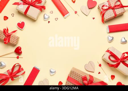 Cornice realizzata in scatole regalo con caramelle e cuori decorativi su sfondo beige. Festa di San Valentino Foto Stock