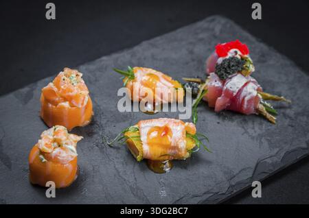 Sushi, cucina tradizionale giapponese. Diversi sushi deliziosi sul piatto decorato, sfondo nero. Gruppo di sushi, Urakami, Nigori, sushi jow, sas Foto Stock