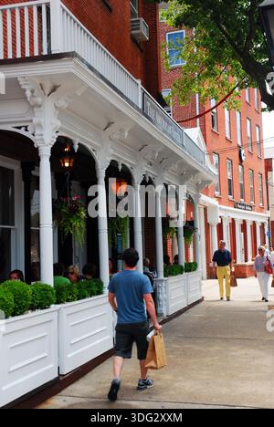 Un giovane porta con sé una borsa della spesa nel centro storico di Sag Harbor, New York, a Long Island Foto Stock