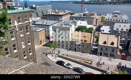 Montreal, QC, Canada - 7 agosto 2025: Edifici storici, strade tortuose e una vivace passeggiata con persone che si godono una giornata estiva in Québec, Canada Foto Stock