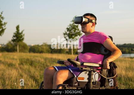 Ritratto dell'uomo disabile che prova il software VR aggiornato nel parco Foto Stock