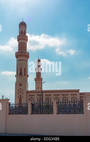 Jamea Sayyida Fatima bint Ali al Said Mosque, al Seeb, Mascate, Oman - 5 gennaio 2024: Una moschea color crema presenta alti minareti ornati contro a. Foto Stock