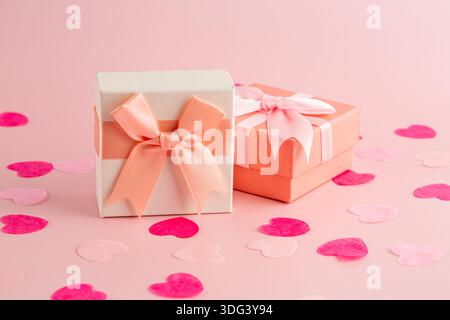 Due confezioni regalo, piccoli cuori rosa e bianchi su sfondo rosa. Foto Stock