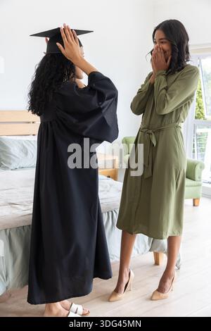 Mamma e figlia adolescente diverse in camera da letto con un cappello regolabile Foto Stock