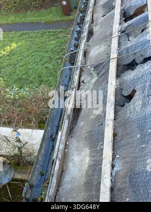 Il tetto della casa è stato danneggiato con l'herpes zoster mancante dopo l'uragano. riparazione del tetto di una casa residenziale. ripristino della membrana impermeabilizzante Foto Stock