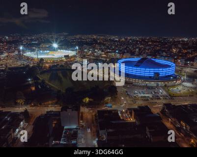 Vista aerea del vivace paesaggio urbano di notte con stadi illuminati e strade animate. Bogotà DC, Colombia Foto Stock