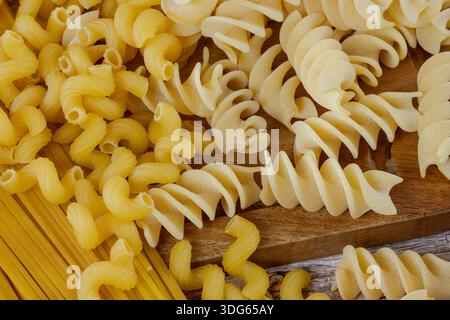 Pasta cruda su tavola di legno Foto Stock