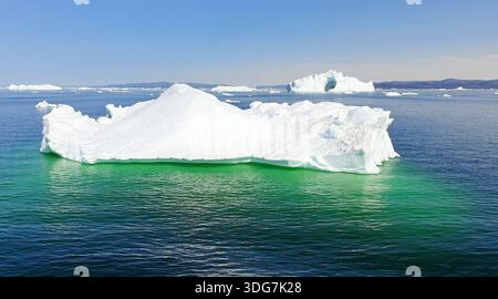 Iceberg bianchi dalla forma strana che galleggiano al largo della costa della Groenlandia occidentale. Un concetto di riscaldamento globale Foto Stock