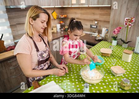 Cuocere con la mamma in un pomeriggio di sole porta gioia Foto Stock