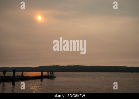 Mukilteo nel tardo pomeriggio d'estate le persone che attraccano la loro barca lungo il molo pubblico in tarda vigilia estiva il cielo era pieno di fumo proveniente da un distan Foto Stock