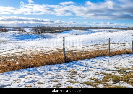 Paesaggio rurale con campi agricoli collinari coperti da un sottile strato di neve Foto Stock