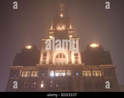 Liverpool, Regno Unito. 16 gennaio 2026. Meteo nel Regno Unito. Una fitta coperta di nebbia ha iniziato a stabilirsi sul Merseyside questa sera. Un avvertimento meteorologico giallo è stato messo in atto con la nebbia che dovrebbe interessare l'intero Merseyside. Questa suggestiva immagine aerea mostra il Royal Liver Building avvolto da una fitta coperta di nebbia notturna. Crediti: Liverpool Live News/Alamy Live News Foto Stock