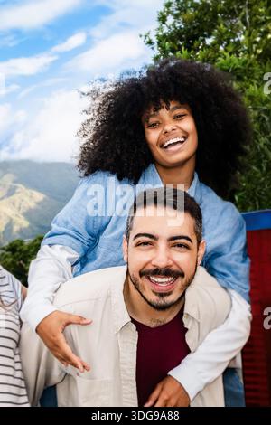 Felice giovane coppia che si diverte insieme nel parco - amore multiculturale stile di vita Foto Stock