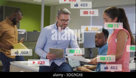 Revisione di documenti, uomo in camicia blu che tiene un team di guida tablet in open Office con sovrapposizioni sociali Foto Stock
