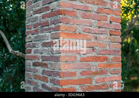 Dettaglio ravvicinato della colonna curva in mattoni rossi con Malta grigia in muratura tradizionale italiana. Foto Stock