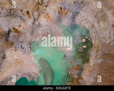 Vista aerea di un paesaggio ultraterreno, una piscina di acqua turchese annidata tra la terra aspra dai toni ocra, Foz do Arelho, Portogallo. Foto Stock