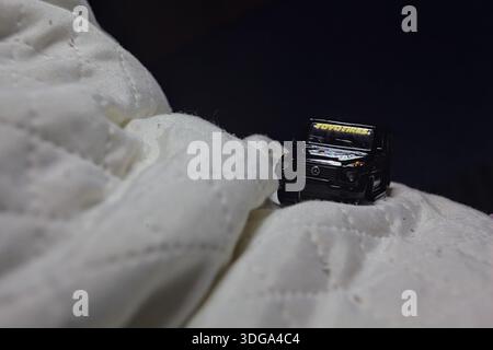 Mantova, Italia - 23 MAGGIO 2025 - Maisto replica di una Mercedes Benz Classe G nera nell'atto di salire sul lato di un cuscino piegato Foto Stock