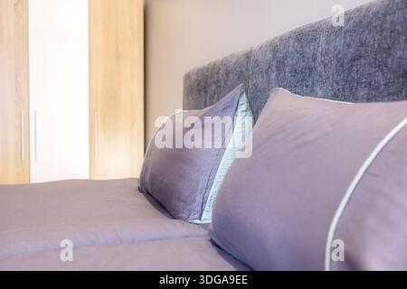Comodi cuscini grigi sul letto, pronta sistemazione per gli ospiti Foto Stock