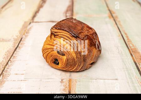 Un'immagine di due pains au chocolat su piatti abbinati, con caffè e succo d'arancia, che evocano una tranquilla mattinata piena di piccoli piaceri Foto Stock