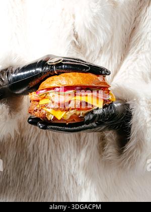 Una donna ha in mano un panino grande Foto Stock