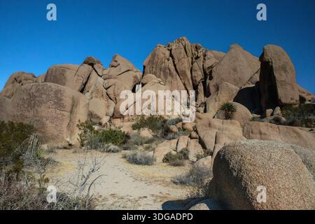 Massicce formazioni rocciose rocciose sotto un profondo cielo blu del deserto Foto Stock