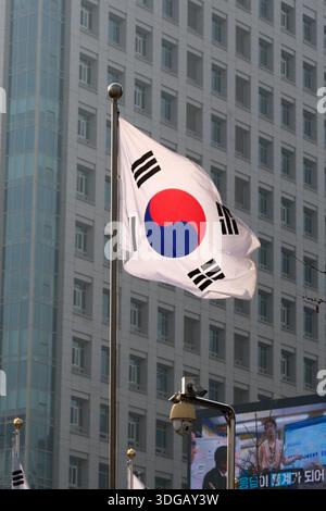 Seoul, Corea del Sud: Bandiera nazionale di Taegeukgi che sventola di fronte al moderno edificio di uffici nel centro di Seoul, simbolo dello stato e dell'identità coreana Foto Stock