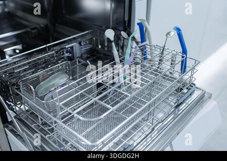 Vista ravvicinata dello specchio dentale e delle mani con i guanti durante l'esame professionale della bocca in clinica Foto Stock