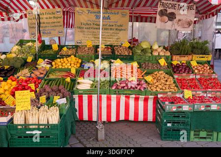 Il colorato mercato di Norimberga offre frutta fresca, verdura e prodotti locali sotto un baldacchino a righe rosso e bianco. Foto Stock