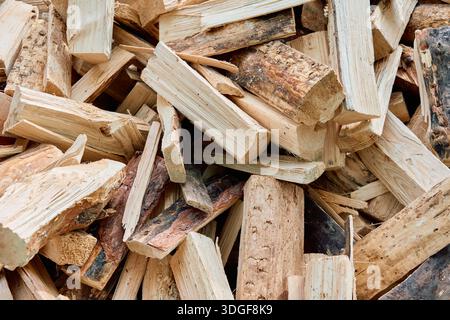Mucchio di tronchi di legna da ardere tritati. Struttura in legno naturale e fondo rustico di tronchi spaccati pronti per il riscaldamento invernale o un caminetto. Foto Stock