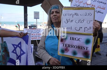 TEL AVIV, ISRAELE - 16 GENNAIO: Una donna ha un segno che dice "terrorista dell'IRGC" riferendosi al corpo delle guardie rivoluzionarie islamiche mentre la gente si riunisce per una marcia a sostegno dei manifestanti iraniani lungo il lungomare, il 16 gennaio 2026 a Tel Aviv, Israele. Gli israeliani si stanno mobilitando in segno di solidarietà con i manifestanti in Iran, dove da dicembre sono in corso manifestazioni anti-governative. Le tensioni sono state elevate nella regione, mentre il presidente degli Stati Uniti Donald Trump ha minacciato l'intervento in Iran per la violenta repressione del governo contro i manifestanti. Foto Stock