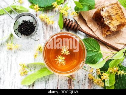 Pettine di miele, tè e fiori di tiglio su una tavola Foto Stock