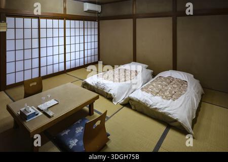 Camera giapponese con pavimento tatami e due letti in un ryokan, Kawaguchi, Yamanashi, Giappone Foto Stock