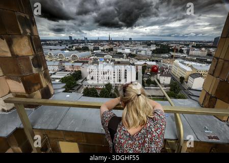Vista dall'Accademia delle Scienze sulla città di riga con una donna premurosa in primo piano, riga, Lettonia, Lettonia Foto Stock