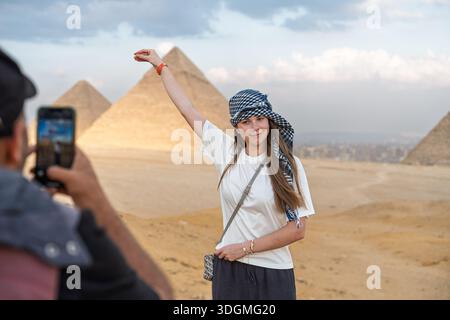 Woman Tourist che posa con le piramidi di Giza, Egitto. Viaggiatore alla scoperta delle meraviglie del mondo antico Foto Stock