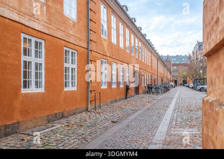 Orange Historic Row Houses, stretta strada acciottolata, Copenhagen, Danimarca Foto Stock