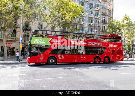 Tour della città di Barcellona e tour panoramico in autobus rosso a due piani, autobus elettrico al 100%, edificio Gaudí Casa Batlló sullo sfondo, Spagna, Europa Foto Stock