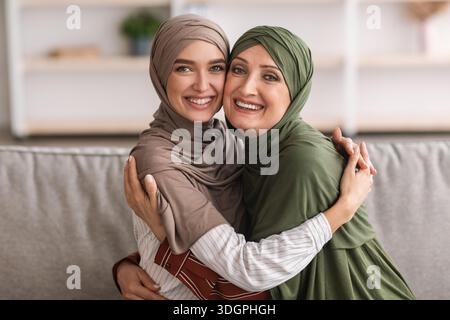 Madre allegra del Medio Oriente e figlia dell'adulto che abbraccia a casa Foto Stock