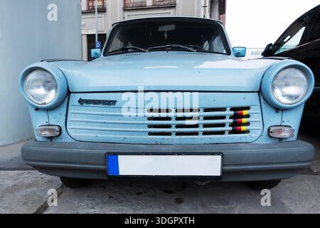 Vista frontale di una Trabant 601 blu, iconica auto della Germania Est dell'era della RDT, parcheggiata su una strada della città Foto Stock