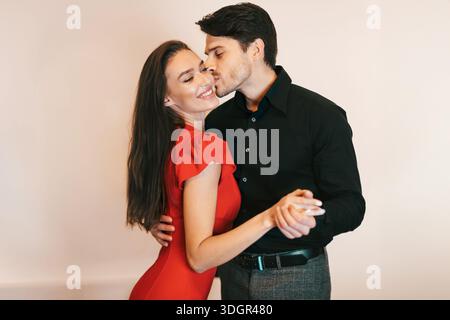 Sorridente ragazzo felice danzando baciare la sua bella donna Foto Stock