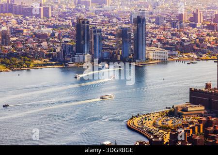 Splendida vista aerea del lungomare di Manhattan lungo l'East River con barche che lasciano onde bianche. New York. STATI UNITI. Foto Stock