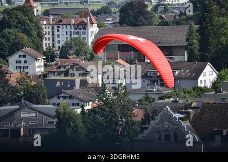 Parapendio sopra Interlaken, Svizzera, con la città sullo sfondo Foto Stock